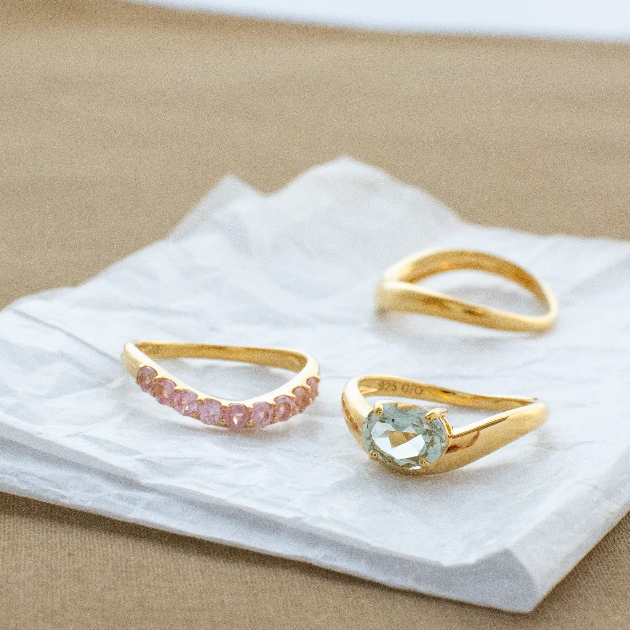 ピンクスピネル エタニティリング、ゴールドのリングと共に並んでいる宝石の美しいデザイン